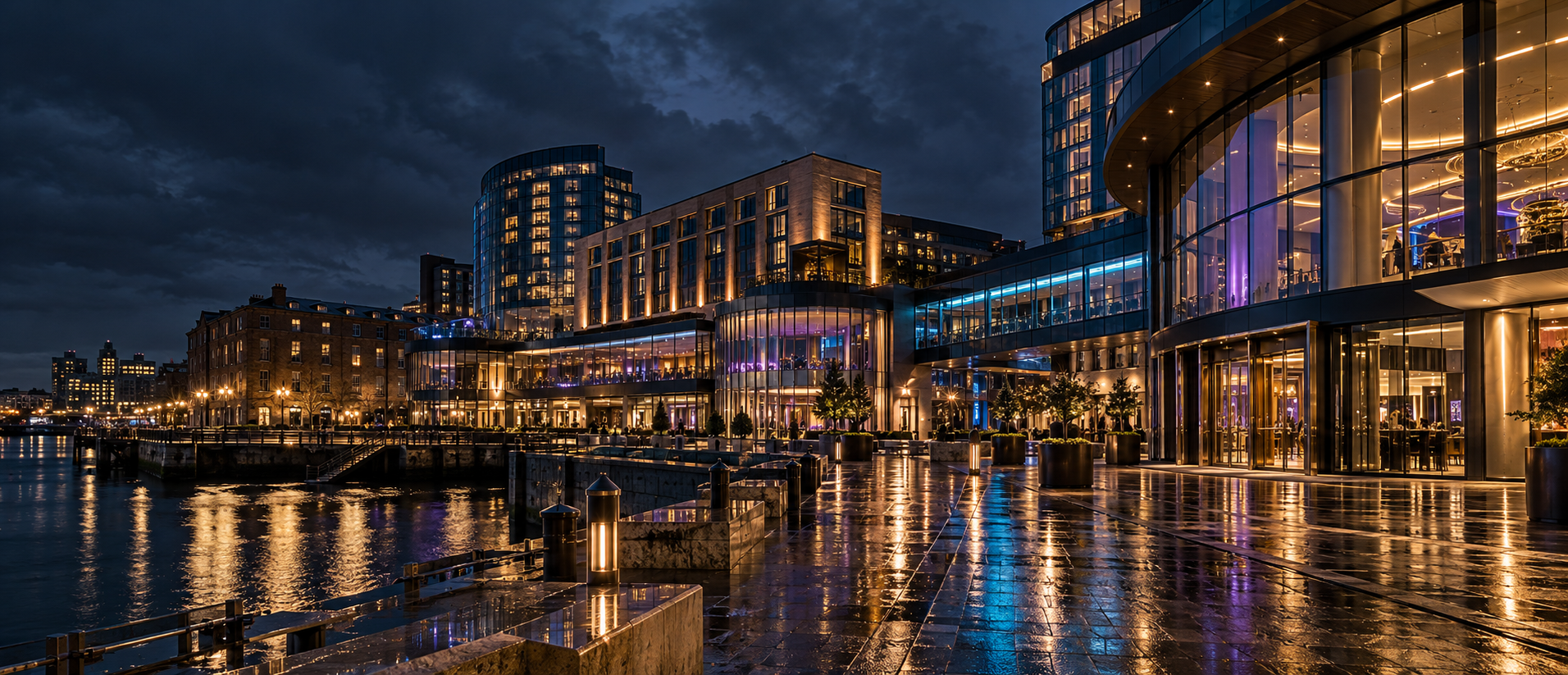 Illuminated United Kingdom waterfront resort reflected on rain-dark pavement at night